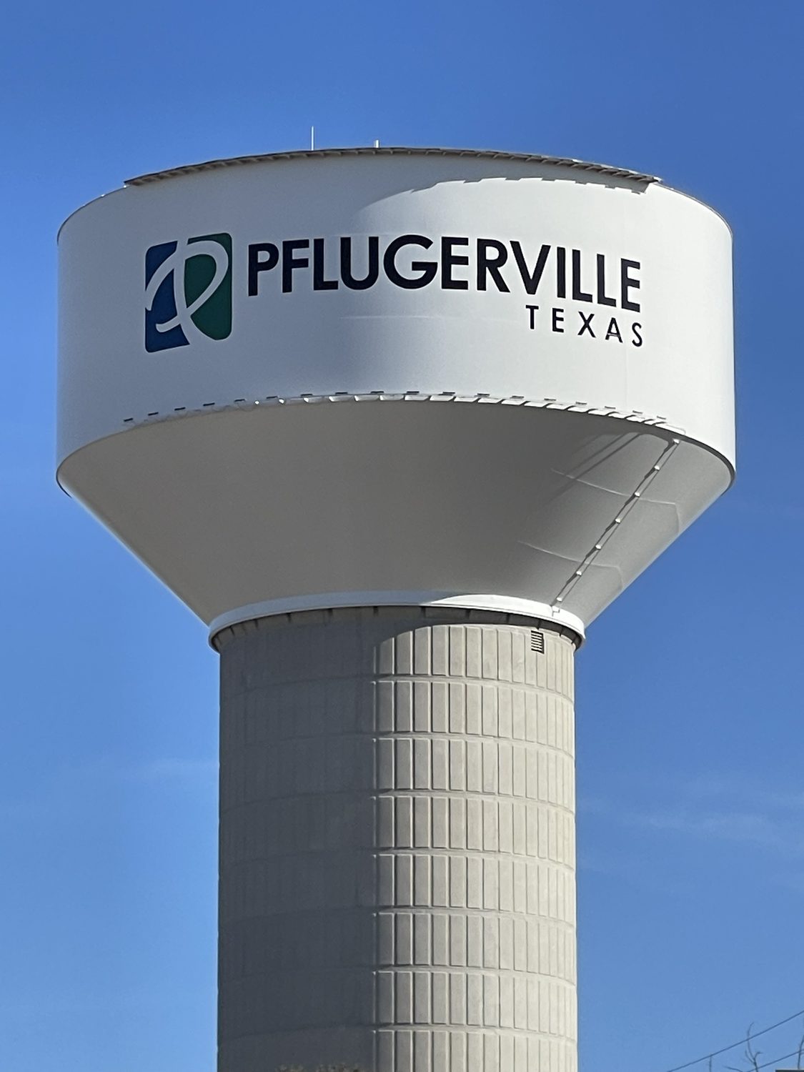 The Pflugerville water tower against a blue Texas sky